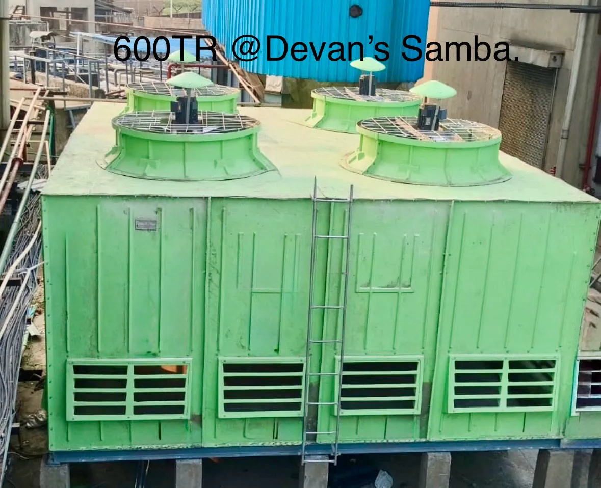 Four cell green FRP rectangular cooling tower rated 600 TR with fan stacks and a stainless access ladder